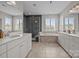 A modern bathroom featuring dual sinks, a glass-enclosed shower, and a soaking tub at 17513 Julees Walk Ln, Davidson, NC 28036