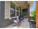 Charming front porch with seating area, stone accents, and beautifully landscaped yard at 17513 Julees Walk Ln, Davidson, NC 28036