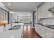 Bright kitchen features white cabinets, countertops, and hardwood floors that lead into the living room at 17513 Julees Walk Ln, Davidson, NC 28036