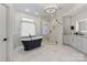 Elegant bathroom features a stand-alone tub, glass shower, and marble floors at 17819 John Connor Rd, Cornelius, NC 28031