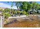 Private beach area with lounge chairs, mature trees, and serene lake views at 17819 John Connor Rd, Cornelius, NC 28031