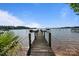 Picturesque wooden dock on the water with clear blue skies and boats in the distance at 17819 John Connor Rd, Cornelius, NC 28031
