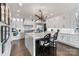 Bright kitchen with white cabinets, a large marble island with seating, and modern light fixture at 17819 John Connor Rd, Cornelius, NC 28031