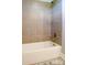 Bathroom featuring a soaking tub with neutral tile surround and updated fixtures at 179 Foy Ln, Statesville, NC 28625