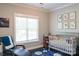 Cozy bedroom featuring a large window, decorative prints, and a crib at 179 Foy Ln, Statesville, NC 28625