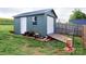 View of backyard shed with roll-up door, standard door, wood storage and access ramp at 179 Foy Ln, Statesville, NC 28625