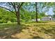 Expansive backyard with mature trees, lush green grass, storage sheds, and plenty of room to roam at 191 Scenic Ne Dr, Concord, NC 28025