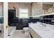 Retro bathroom with a tub, black tiling, floral wallpaper, and a white sink and toilet at 191 Scenic Ne Dr, Concord, NC 28025