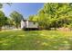 The home has a spacious backyard with a fenced yard, trees, and a wood deck on the back of the home at 201 Trinity St, Clover, SC 29710