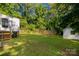 Lush backyard with well-maintained grass, wooden fence, and a storage shed surrounded by trees at 201 Trinity St, Clover, SC 29710