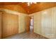 Cozy bedroom featuring wooden ceiling and walls, with a closet and doorway leading to another room at 201 Trinity St, Clover, SC 29710