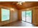 Well-lit room with wooden walls, a window, and a sliding glass door opening to a deck at 201 Trinity St, Clover, SC 29710