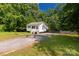 Exterior view of the charming home with gravel driveway and surrounding trees at 201 Trinity St, Clover, SC 29710