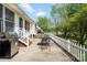 Backyard patio featuring a grill, table, chairs, white fence, and lawn with a pond view at 202 Pond View Dr, Salisbury, NC 28147