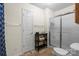 Neutral bathroom with a glass door shower, white door, and dark storage table at 202 Pond View Dr, Salisbury, NC 28147