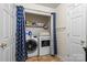 Laundry room features a modern washer, dryer, storage, and blue patterned curtain at 202 Pond View Dr, Salisbury, NC 28147