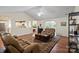 Open-concept living room with hardwood floors, vaulted ceiling, leather seating and decorative shelving and kitchen view at 202 Pond View Dr, Salisbury, NC 28147
