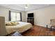 Spacious main bedroom with tray ceiling, hardwood floors, large window with seating area, and ensuite bathroom at 202 Pond View Dr, Salisbury, NC 28147