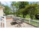 Back patio with table and chairs overlooking a lawn, pond, and trees at 202 Pond View Dr, Salisbury, NC 28147