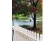 Scenic pond view featuring a fountain and a white picket fence, with fall foliage enhancing the tranquil setting at 202 Pond View Dr, Salisbury, NC 28147
