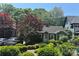 Charming home with a lush, landscaped front yard featuring mature trees and vibrant shrubbery at 2112 Bay St, Charlotte, NC 28205