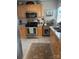 Well-lit kitchen featuring light wood cabinets, stainless steel appliances, and a decorative dragonfly rug at 2112 Bay St, Charlotte, NC 28205