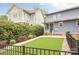 Spacious backyard featuring manicured lawn, professional landscaping, and a black iron fence at 2117 Roslyn Ave, Charlotte, NC 28208