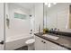 Well-lit bathroom features a shower and tub combination, as well as dark granite countertops at 2117 Roslyn Ave, Charlotte, NC 28208