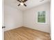 Bright bedroom features hardwood floors, a ceiling fan, and a window letting in natural light at 2117 Roslyn Ave, Charlotte, NC 28208