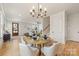 Open dining area with stylish chandelier, table seating four, hardwood floors, and seamless flow to the living area at 2117 Roslyn Ave, Charlotte, NC 28208