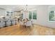 Dining area with a round table, chandelier, hardwood floors, bright lighting, and view of backyard at 2117 Roslyn Ave, Charlotte, NC 28208
