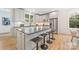 Contemporary kitchen with a large island, white cabinetry, stainless steel appliances, and hardwood floors at 2117 Roslyn Ave, Charlotte, NC 28208