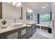 Bright bathroom features dual sinks, a soaking tub and a large window with a serene view at 2345 Sparrow Dr, Rock Hill, SC 29732