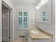 Cozy bathroom featuring a window with shutters, a single vanity, and classic tiling throughout at 2410 Armstrong Park Dr, Gastonia, NC 28054