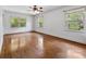 Bedroom showcasing hardwood floors, three windows allowing natural light, and ceiling fan at 2410 Armstrong Park Dr, Gastonia, NC 28054