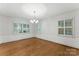 Dining room featuring hardwood floors, a modern chandelier, and large windows with shutters at 2410 Armstrong Park Dr, Gastonia, NC 28054