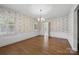 Traditional dining room with hardwood floors, chandelier lighting, and classic wallpaper design at 2410 Armstrong Park Dr, Gastonia, NC 28054