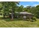 Beautiful brick house with mature trees, a well-manicured lawn, and lush landscaping providing excellent curb appeal at 2410 Armstrong Park Dr, Gastonia, NC 28054