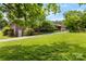 Charming brick home on a sprawling green lawn with mature trees and a paved driveway leading to a garage at 2410 Armstrong Park Dr, Gastonia, NC 28054