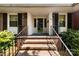 Inviting brick front entrance with black iron railings and a storm door for a classic aesthetic at 2410 Armstrong Park Dr, Gastonia, NC 28054
