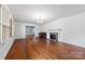 Spacious living room with a fireplace, piano, hardwood floors, and a decorative chandelier at 2410 Armstrong Park Dr, Gastonia, NC 28054