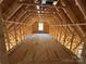 Attic framing showing the support structure, floor decking, and window opening in this new home construction at 28770 Hwy 73 Hwy, Albemarle, NC 28001