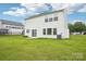 View of the home's backyard featuring a lawn, an air conditioning unit, and a sliding glass door at 3038 Old Ironside Dr, Charlotte, NC 28213