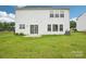 Back exterior shot of the home showcasing the lush lawn, A/C unit, and sliding glass door to the patio at 3038 Old Ironside Dr, Charlotte, NC 28213
