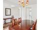 Formal dining room features a wooden table and chairs beneath a beautiful chandelier light fixture at 3038 Old Ironside Dr, Charlotte, NC 28213