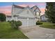 Charming two-story home boasts a two-car garage and well-maintained landscaping at sunset at 3038 Old Ironside Dr, Charlotte, NC 28213