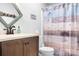 Cozy bathroom features a wood-look shower curtain, granite countertop, and a rustic mirror at 317 Marietta Rd, Mooresville, NC 28117