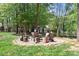 Cozy outdoor fire pit area featuring rustic seating surrounded by trees and lush greenery at 317 Marietta Rd, Mooresville, NC 28117
