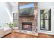 Close up of the stone fireplace and mantle, with large windows on each side, and hardwood floors at 317 Marietta Rd, Mooresville, NC 28117
