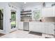 Bright kitchen featuring white cabinets, stainless steel appliances, open shelving, and backyard views at 317 Marietta Rd, Mooresville, NC 28117